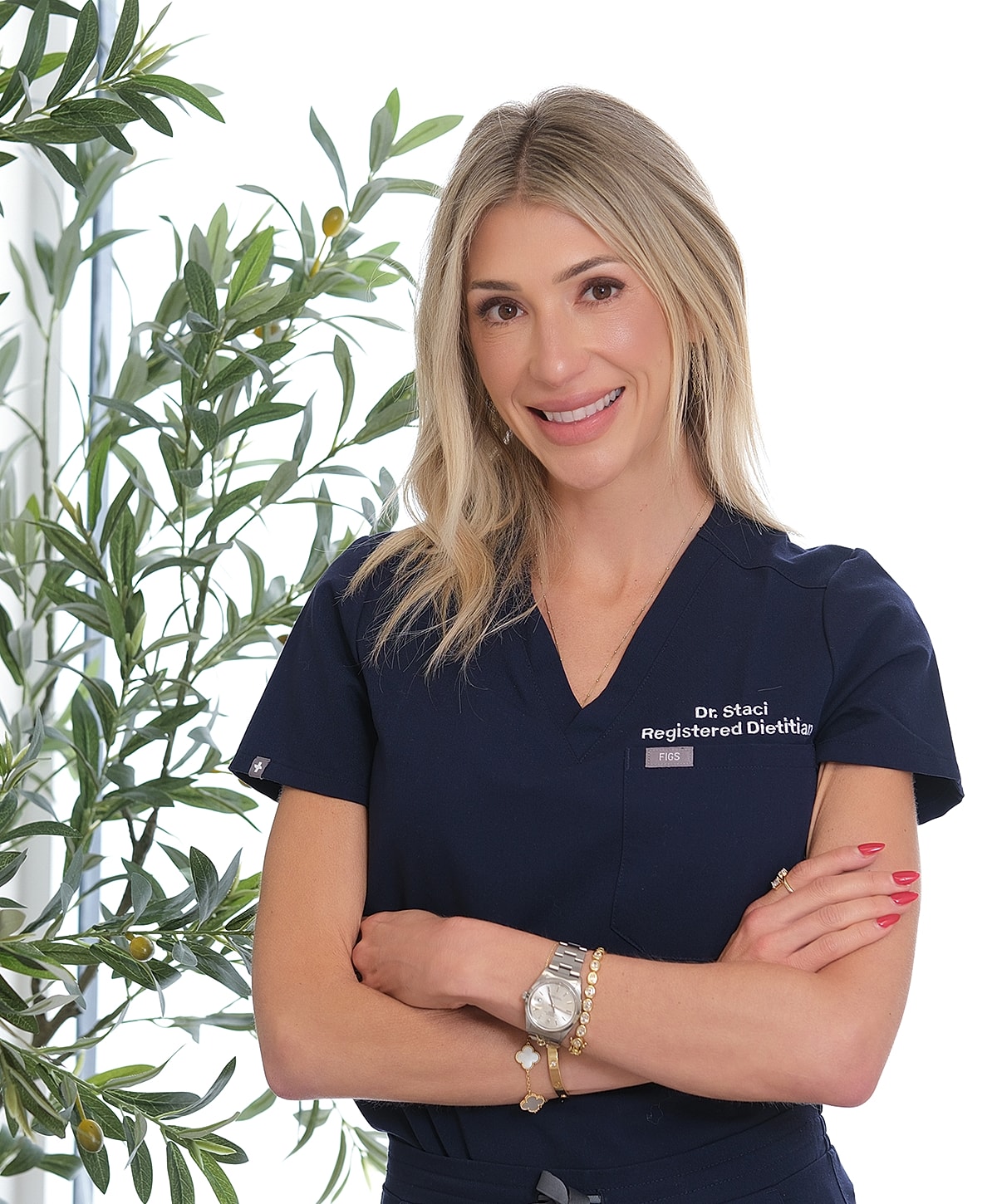 Dietitian smiling in professional attire with plants.