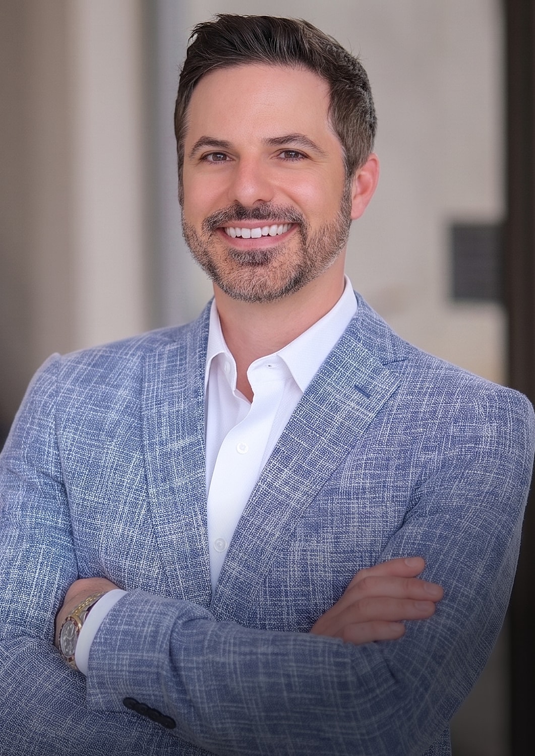 Smiling man in a blue blazer portrait.